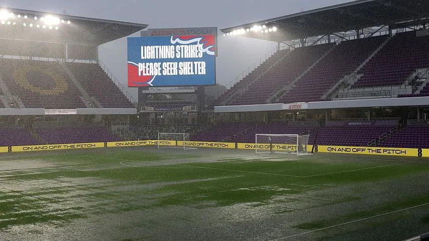 Heavy rain briefly floods the Inter&Co Stadium pitch in Orlando before England's match against Costa Rica, while a large screen carries the message LIGHTNING STRIKES PLEASE SEEK SHELTER