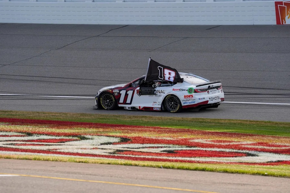 NASCAR Cup Series driver Denny Hamlin (11) drives with a flag after his victory at the FireKeepers Casino 400 at Michigan International Speedway. Paul Barnick-Imagn Images
