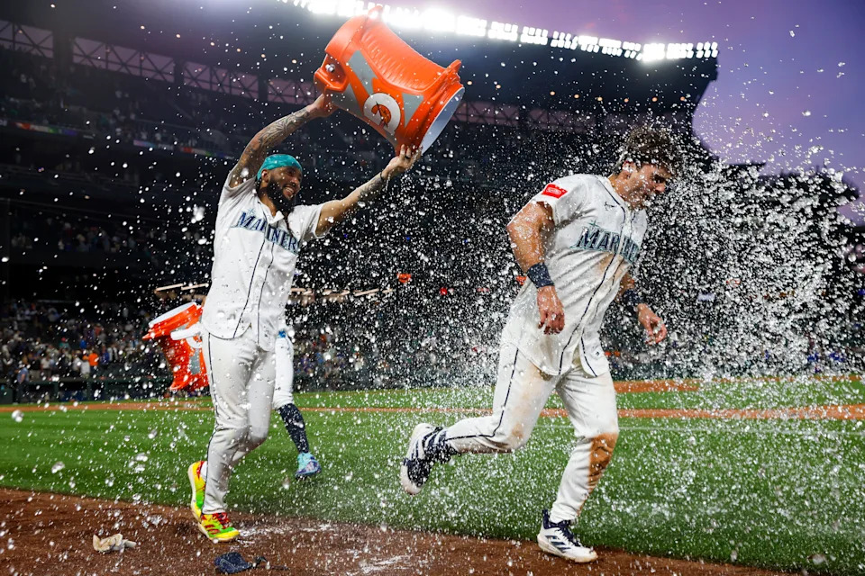 "He's had such a huge impact on me," Seattle Mariners infielder Cole Young, right, says of J.P. Crawford, here dousing him with a sports drink after a walk-off single June 1.