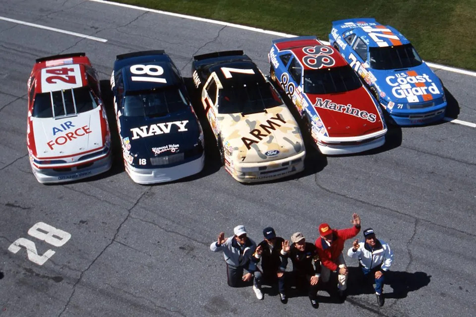 DAYTONA BEACH, FL - FEBRUARY 1991: Several drivers honored the U.S. Armed Forces during Desert Storm for the running of the Daytona 500 NASCAR Cup race at Daytona International Speedway. (L-R) No. 24 Mickey Gibbs (Air Force), No. 18 Greg Sacks (Navy), No. 7 Alan Kulwicki (Army), No. 88 Buddy Baker (Marine Corps) and No. 71 Dave Marcis (Coast Guard). (Photo by ISC Images & Archives via Getty Images)
