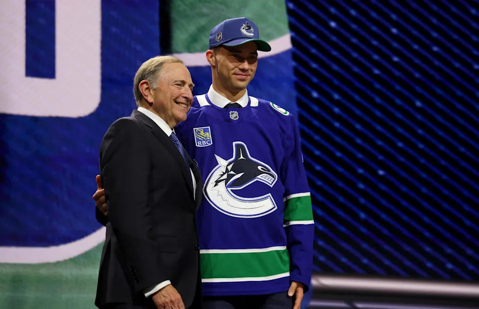 Jun 26, 2026; Buffalo, New York, USA; Adam Novotny reacts beside NHL commissioner Gary Bettman after being selected with the twenty fourth pick in the first round of the 2026 NHL Draft by the Vancouver Canucks at KeyBank Center. Mandatory Credit: Timothy T. Ludwig-Imagn Images