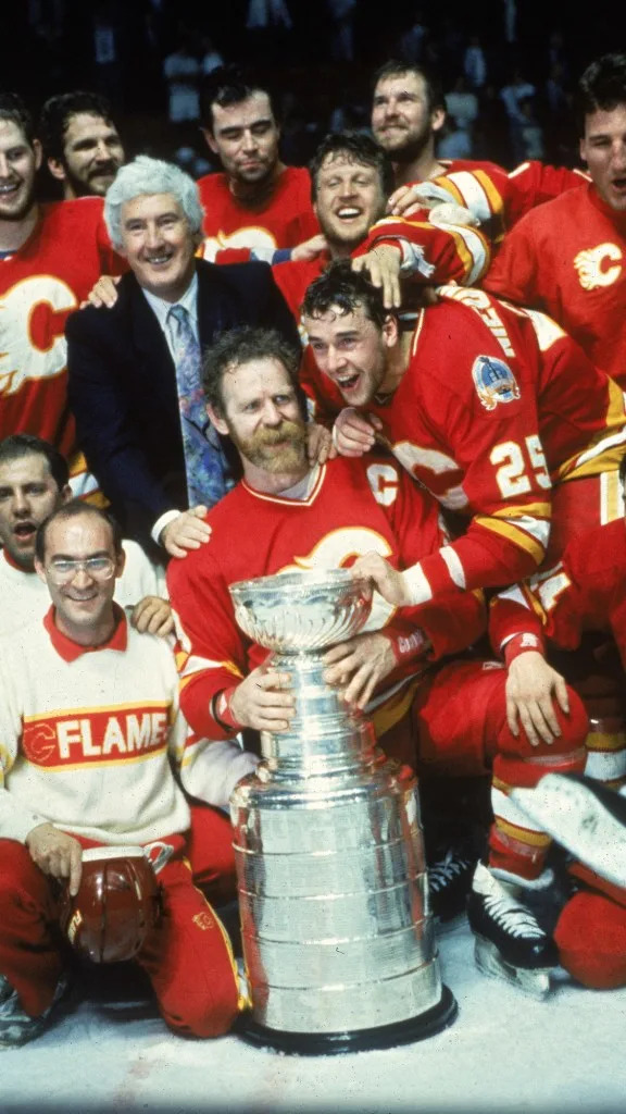 Cliff Fletcher, wearing a suit, celebrates after <br>winning a Stanley Cup with the Flames in 1989. Bruce Bennett Studios via Getty Images Studios/Getty Images