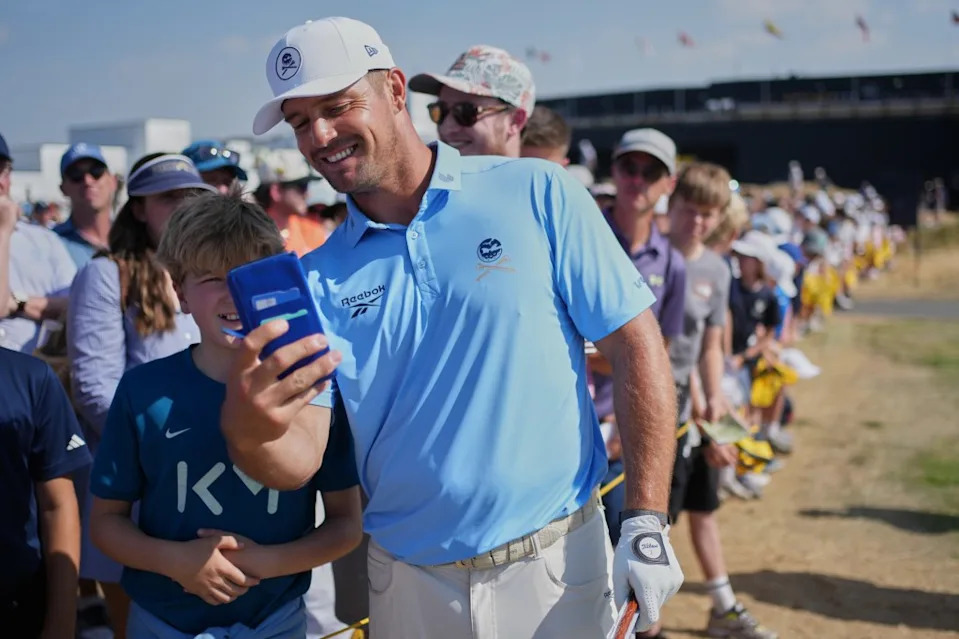 Bryson DeChambeau of the United States poses with fans and signs autographs by the 9th hole during a practice round for the British Open Golf championships at Royal Birkdale golf club, in Southport, England, Tuesday, July 14, 2026. AP Photo/Jon Super