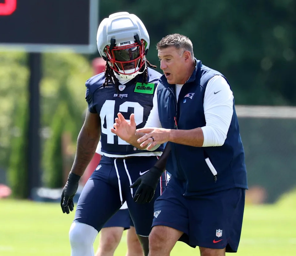 Patriots head coach Mike Vrabel works with linebacker <a class="link " href="https://sports.yahoo.com/nfl/players/34212/" data-i13n="sec:content-canvas;subsec:anchor_text;elm:context_link" data-ylk="slk:Jesse Luketa;sec:content-canvas;subsec:anchor_text;elm:context_link;itc:0" data-yga="{"yLinkElement":"context_link","yModuleName":"content-canvas","yLinkText":"Jesse Luketa","ySubModuleName":"anchor_text","yHasCommerce":false}">Jesse Luketa</a> during the team’s first day of training camp<br>on July 25, 2026, in Foxborough, Mass. AP Photo/Mark Stockwell