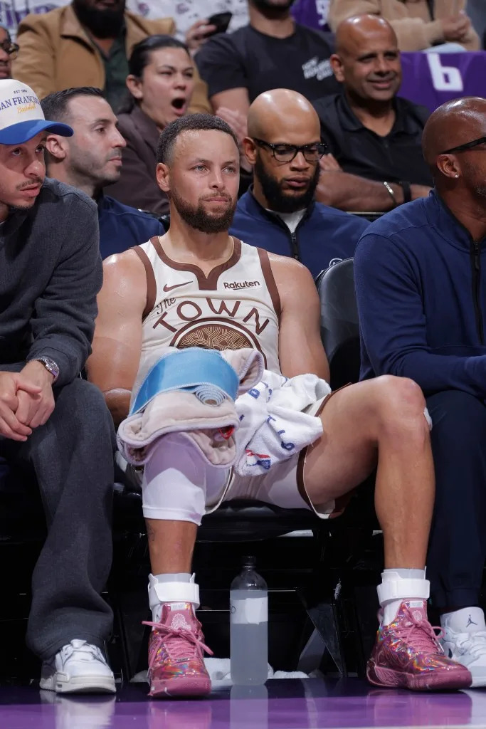 Stephen Curry looks on from the bench during the game against the <a class="link " href="https://sports.yahoo.com/nba/teams/sacramento/" data-i13n="sec:content-canvas;subsec:anchor_text;elm:context_link" data-ylk="slk:Sacramento Kings;sec:content-canvas;subsec:anchor_text;elm:context_link;itc:0" data-yga="{"yLinkElement":"context_link","yModuleName":"content-canvas","yLinkText":"Sacramento Kings","ySubModuleName":"anchor_text","yHasCommerce":false}">Sacramento Kings</a>. NBAE via Getty Images